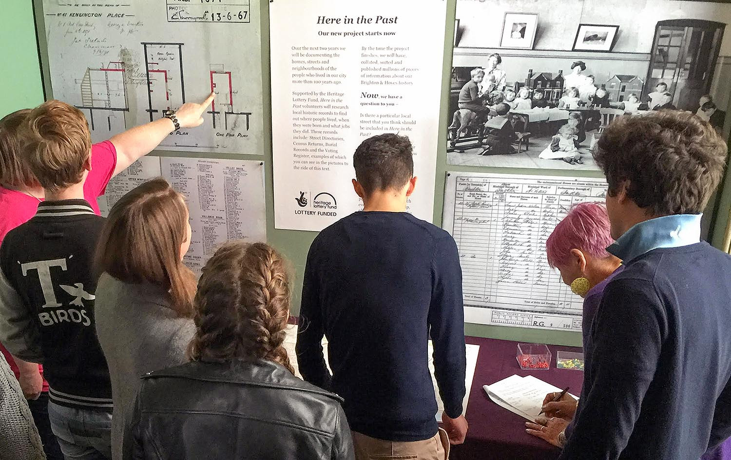 Here in the Past exhibition boards being examined by a group of students