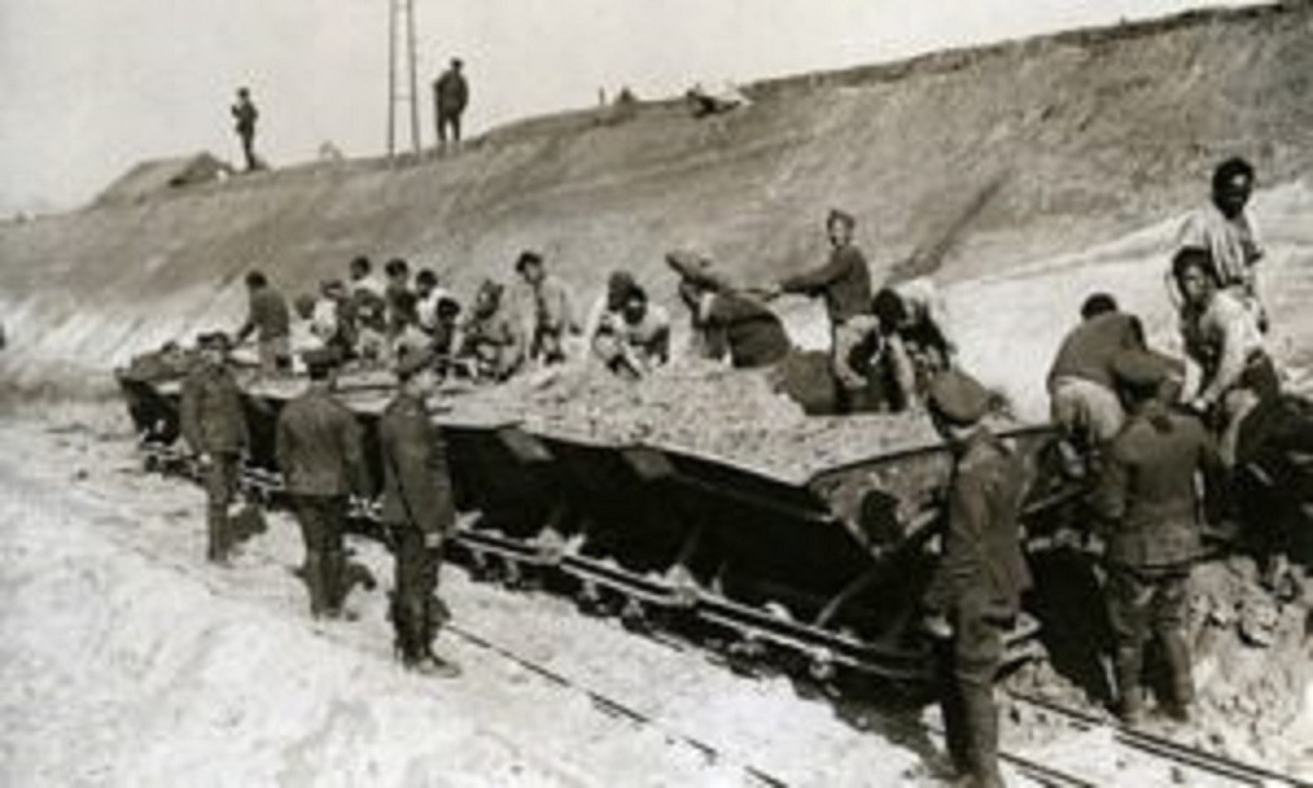 Black and white photograph showing Chinese workers building a road 